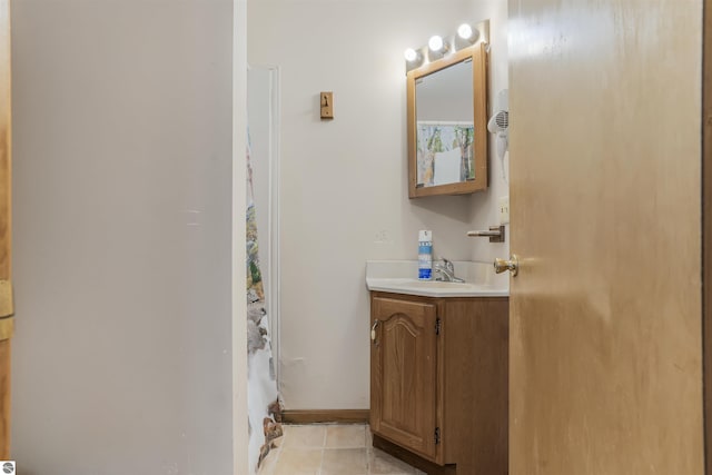 8377 Zosel St, Onekama, MI 49675 - bathroom featuring tile patterned flooring, vanity, a shower with curtain, and baseboards