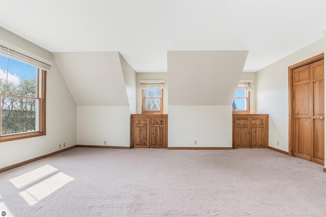 8377 Zosel St, Onekama, MI 49675 - additional living space with healthy amount of natural light, light colored carpet, baseboards, and vaulted ceiling