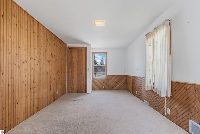 8377 Zosel St, Onekama, MI 49675 - unfurnished room with wood walls, wainscoting, and carpet