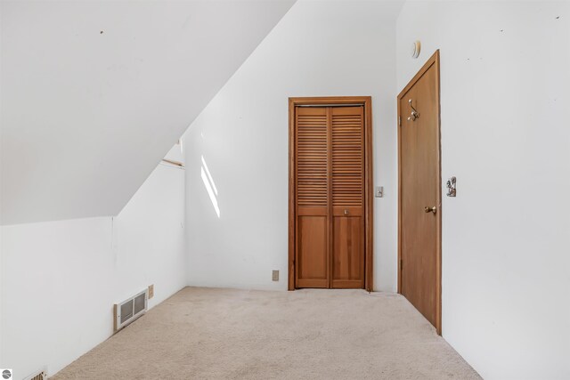 8377 Zosel St, Onekama, MI 49675 - additional living space with vaulted ceiling and carpet flooring