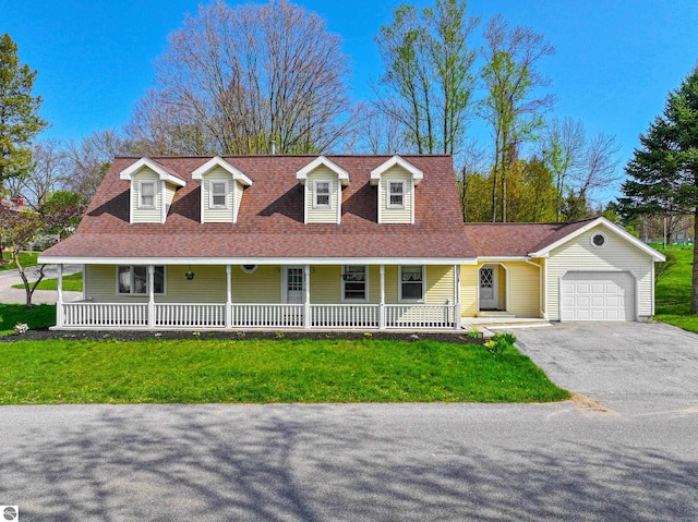 8377 Zosel St, Onekama, MI 49675 - farmhouse with a porch, a garage, driveway, and a front yard