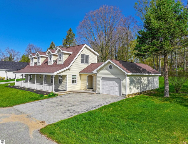 8377 Zosel St, Onekama, MI 49675 - view of front facade with a garage, covered porch, driveway, and a front yard