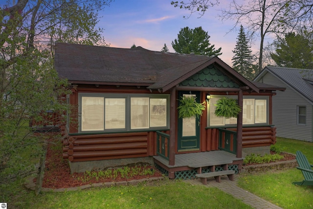 66 N Center St, Lake City, MI 49651 - log cabin with entry steps, log siding, a front lawn, and roof with shingles