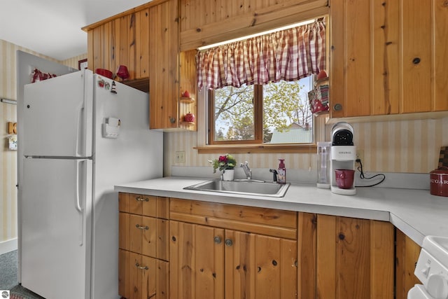 66 N Center St, Lake City, MI 49651 - kitchen featuring freestanding refrigerator, a sink, light countertops, and brown cabinetry