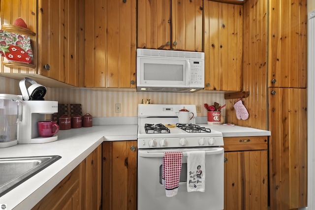 66 N Center St, Lake City, MI 49651 - kitchen featuring white appliances, brown cabinets, and light countertops