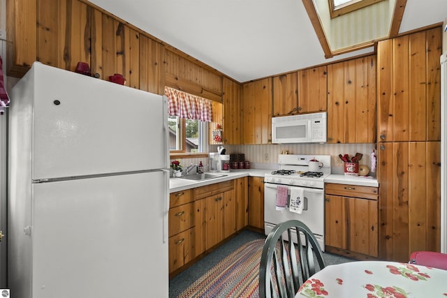 66 N Center St, Lake City, MI 49651 - kitchen with white appliances, light countertops, brown cabinets, a sink, and wooden walls