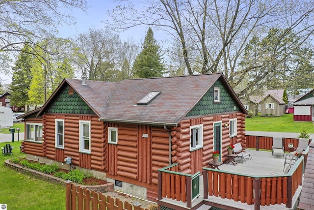 66 N Center St, Lake City, MI 49651 - rear view of house with log siding, a deck, a yard, and crawl space