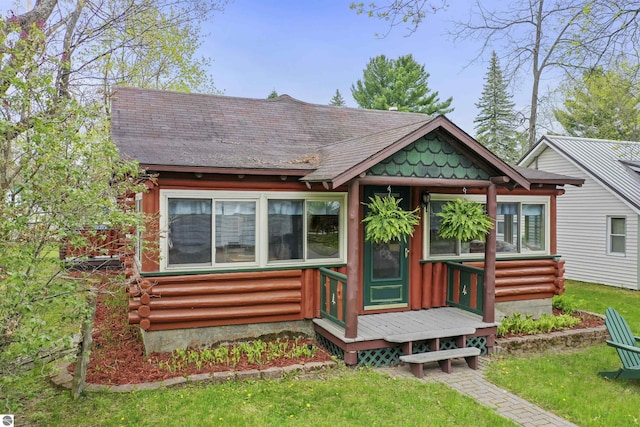 66 N Center St, Lake City, MI 49651 - view of front facade with entry steps, log siding, and a front yard