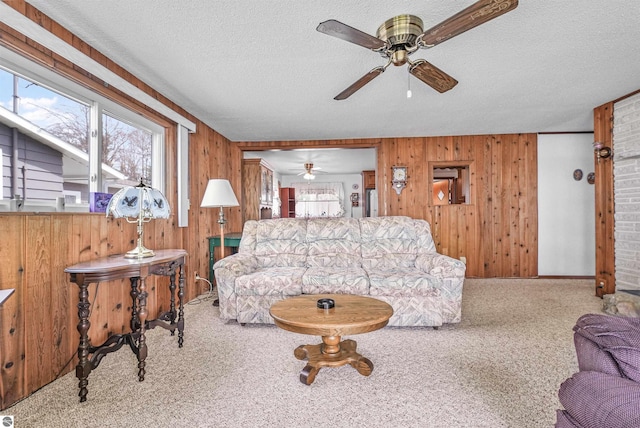8805 Iroquois Trl, Saint Helen, MI 48656 - living room with a ceiling fan, carpet flooring, wood walls, and a textured ceiling