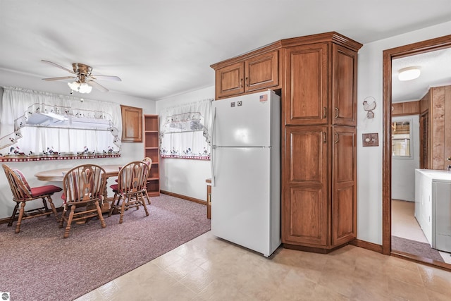 8805 Iroquois Trl, Saint Helen, MI 48656 - kitchen with freestanding refrigerator, ceiling fan, baseboards, and brown cabinetry