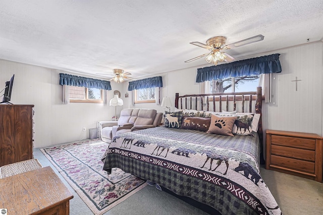 8805 Iroquois Trl, Saint Helen, MI 48656 - bedroom with carpet, ceiling fan, a textured ceiling, and wooden walls