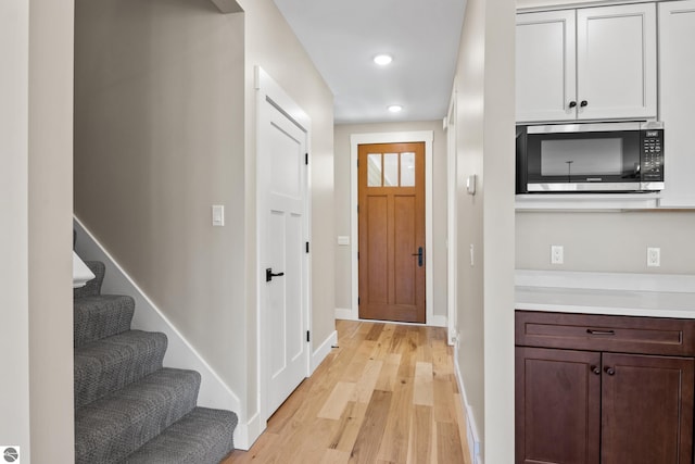3046 E Greenwood Rd, Lake Leelanau, MI 49653 - entrance foyer with light wood-style floors, baseboards, recessed lighting, and stairway