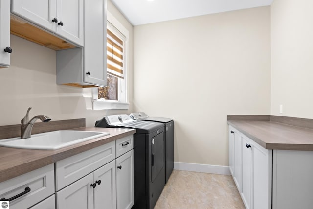 3046 E Greenwood Rd, Lake Leelanau, MI 49653 - laundry area featuring independent washer and dryer, cabinet space, and baseboards