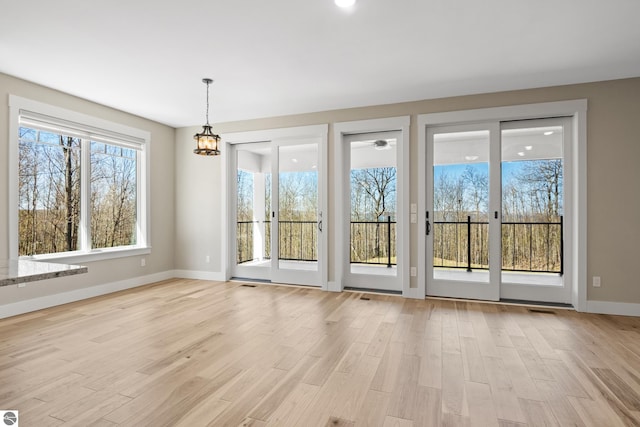3046 E Greenwood Rd, Lake Leelanau, MI 49653 - doorway with light wood finished floors, baseboards, and plenty of natural light