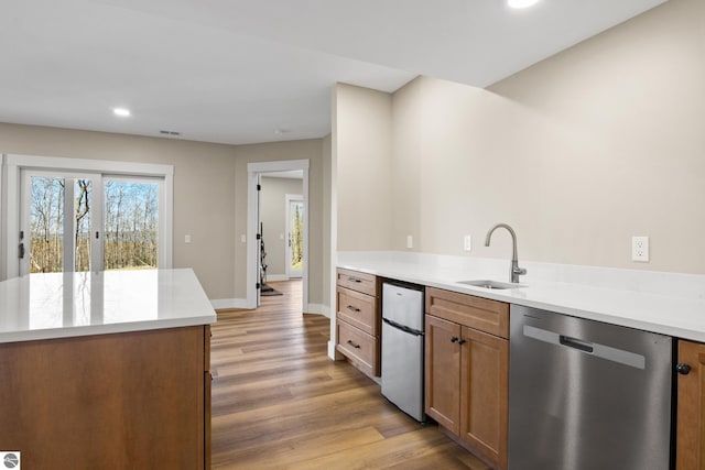 3046 E Greenwood Rd, Lake Leelanau, MI 49653 - kitchen featuring dishwasher, a sink, light wood finished floors, baseboards, and recessed lighting