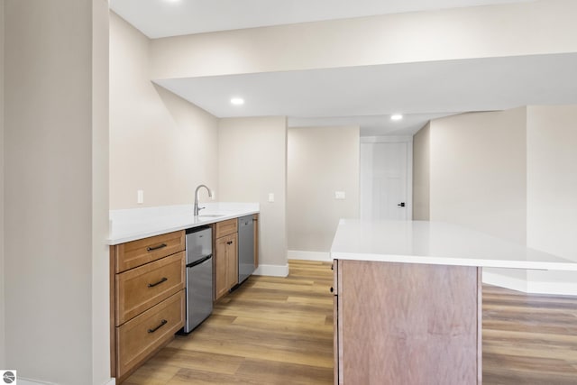 3046 E Greenwood Rd, Lake Leelanau, MI 49653 - kitchen with appliances with stainless steel finishes, light wood-type flooring, baseboards, a kitchen island, and a sink