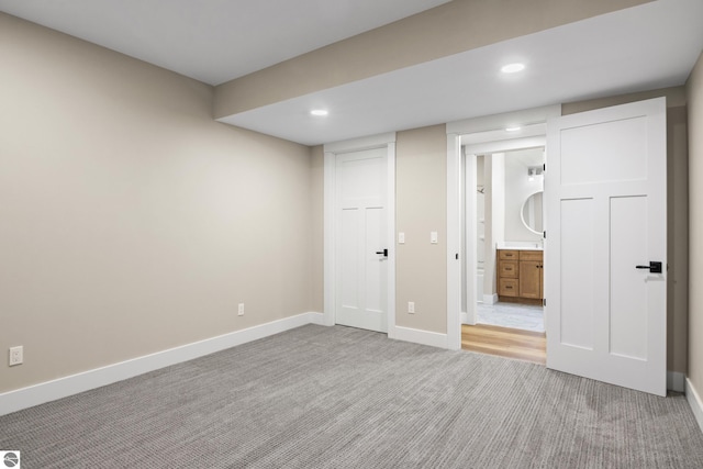 3046 E Greenwood Rd, Lake Leelanau, MI 49653 - unfurnished bedroom with light colored carpet, baseboards, recessed lighting, and connected bathroom