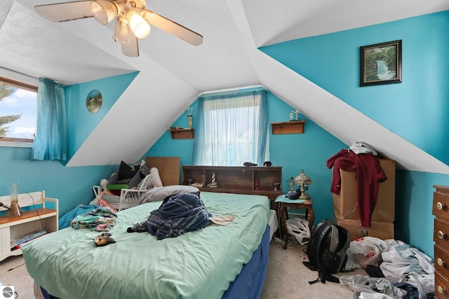 512 NW Kalkaska St, Kalkaska, MI 49646 - carpeted bedroom with multiple windows, vaulted ceiling, and a ceiling fan