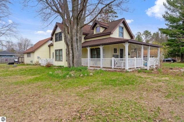 512 NW Kalkaska St, Kalkaska, MI 49646 - view of front of house featuring covered porch, a front lawn, and a shingled roof