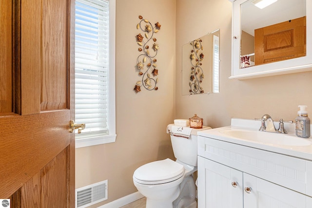 full bath featuring toilet, vanity, and baseboards