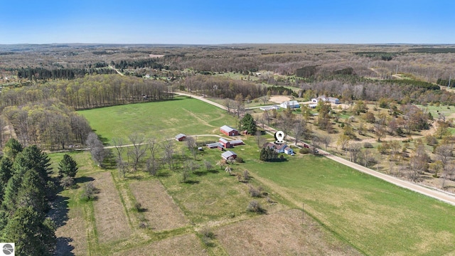 aerial view of property and surrounding area with a heavily wooded area