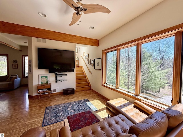 living area with wood finished floors, stairs, ceiling fan, recessed lighting, and beamed ceiling