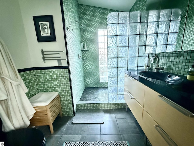 full bath featuring tile walls, tile patterned flooring, a walk in shower, and vanity