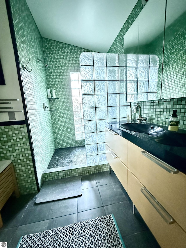 full bath featuring tile walls, tile patterned floors, vanity, and walk in shower