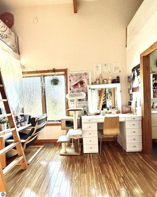 office area with built in study area, hardwood / wood-style floors, and high vaulted ceiling