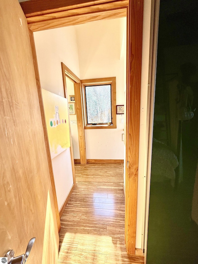 corridor with wood finished floors and baseboards