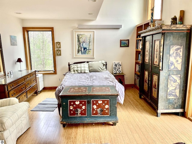 bedroom featuring baseboards, wood finished floors, and recessed lighting