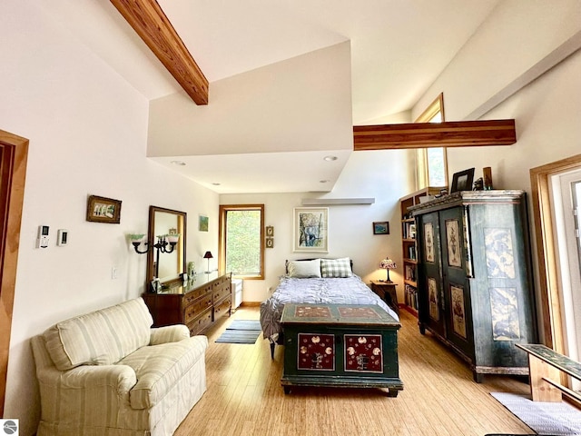 bedroom with multiple windows, wood finished floors, and beam ceiling