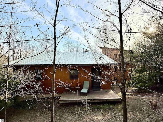 view of property exterior featuring metal roof, a wooden deck, and board and batten siding