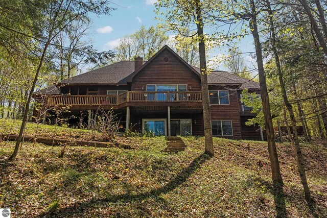4854 Forest Trl, Bellaire, MI 49615 - back of property with roof with shingles, a deck, and a chimney