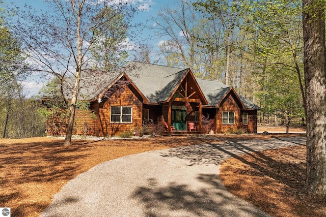 4854 Forest Trl, Bellaire, MI 49615 - log-style house featuring curved driveway and covered porch