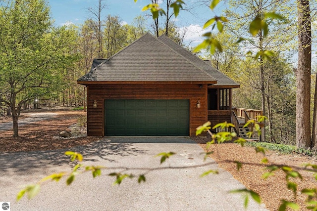 4854 Forest Trl, Bellaire, MI 49615 - view of front of home featuring roof with shingles, asphalt driveway, and an attached garage