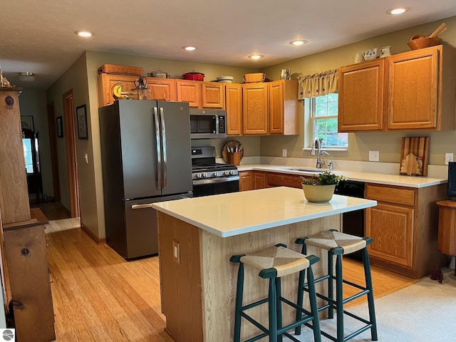 6557 Betsie River Rd, Interlochen, MI 49643 - kitchen with appliances with stainless steel finishes, a sink, light wood-type flooring, a kitchen bar, and recessed lighting