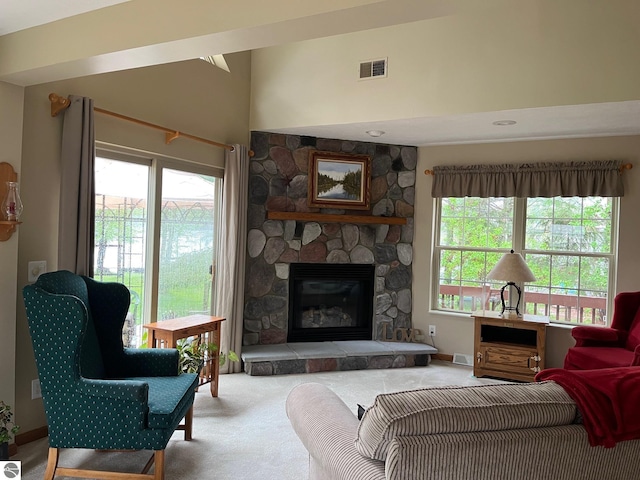 6557 Betsie River Rd, Interlochen, MI 49643 - living area with carpet, a fireplace, and a towering ceiling