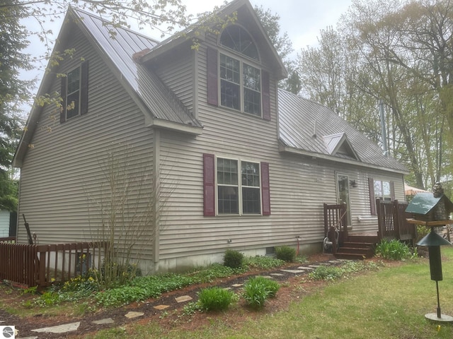 6557 Betsie River Rd, Interlochen, MI 49643 - rear view of house with metal roof and a deck