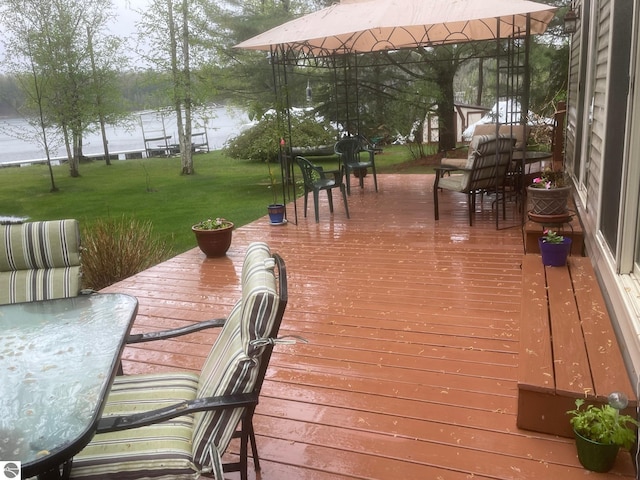 6557 Betsie River Rd, Interlochen, MI 49643 - deck featuring a lawn, a gazebo, and outdoor dining space
