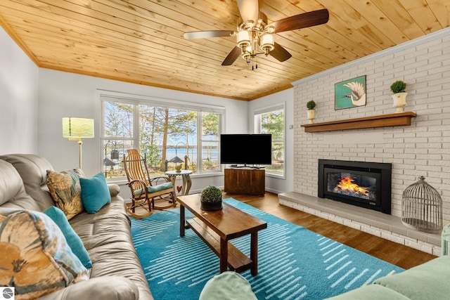 4306 Central Park Dr, Grawn, MI 49637 - living area with ornamental molding, wood ceiling, wood finished floors, a ceiling fan, and a brick fireplace