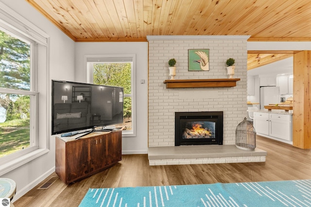 4306 Central Park Dr, Grawn, MI 49637 - living room with ornamental molding, wood finished floors, a brick fireplace, baseboards, and wooden ceiling