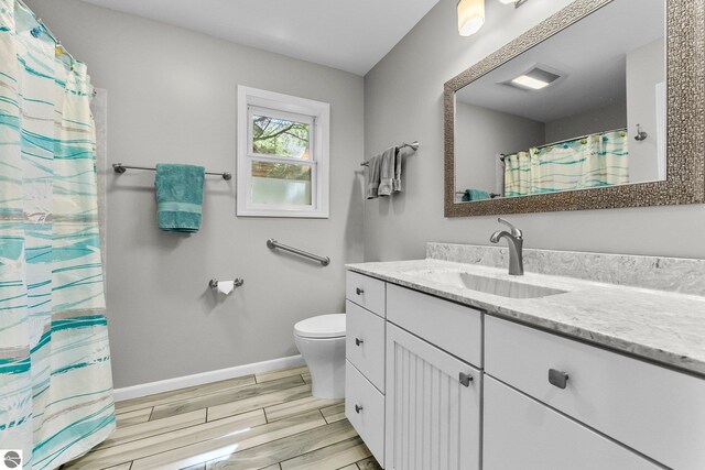 4306 Central Park Dr, Grawn, MI 49637 - bathroom with baseboards, wood finish floors, vanity, toilet, and curtained shower