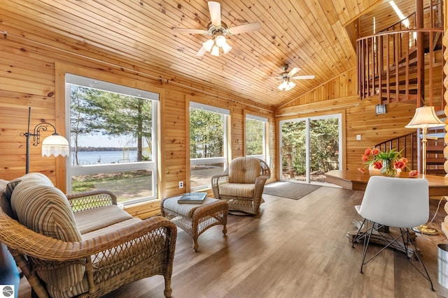 4306 Central Park Dr, Grawn, MI 49637 - living room with wooden walls, ceiling fan, lofted ceiling, a water view, and wood finished floors