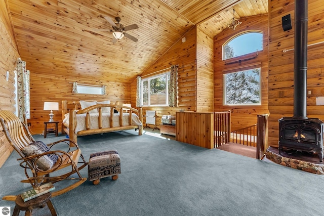 4306 Central Park Dr, Grawn, MI 49637 - carpeted bedroom featuring high vaulted ceiling, multiple windows, a wood stove, wood ceiling, and wood walls