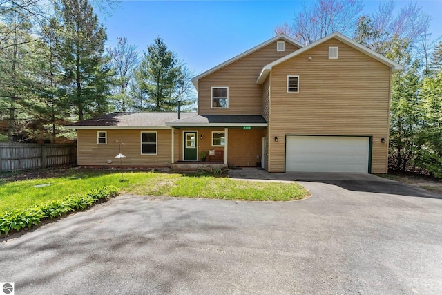 4306 Central Park Dr, Grawn, MI 49637 - view of front of home featuring fence, driveway, covered porch, and a garage