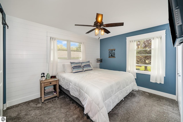 1254 Queensway Dr, Lake Isabella, MI 48893 - bedroom featuring dark carpet, baseboards, wood walls, and multiple windows