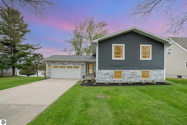 1254 Queensway Dr, Lake Isabella, MI 48893 - tri-level home featuring driveway, an attached garage, a front yard, and stone siding