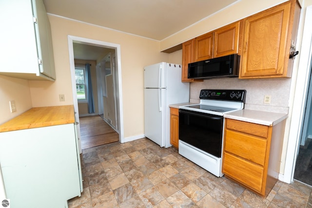 1618 E High, Mount Pleasant, MI 48858 - kitchen featuring white appliances, stone finish floors, light countertops, and baseboards