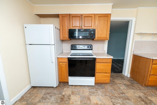 1618 E High, Mount Pleasant, MI 48858 - kitchen with black microwave, freestanding refrigerator, electric range, baseboards, and light countertops